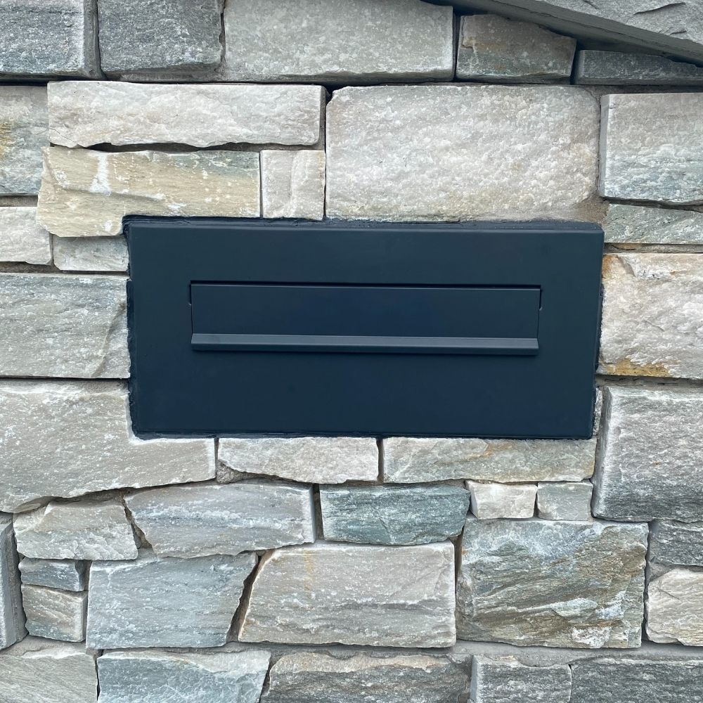 Built in post box in stone wall 